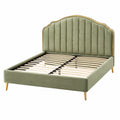 Lit en velours vert avec tête de lit capitonnée et pieds métalliques